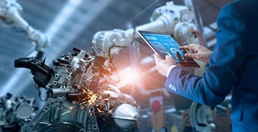 man using tablet in front of machinery